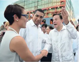  ?? CONTRIBUTE­D ?? Prime Minister Andrew Holness (centre) looks on as President of Panama Juan Carlos Varela greets Minister of Foreign Affairs and Foreign Trade, Senator Kamina Johnson Smith, at the opening of the expanded Panama Canal in Panama City on June 26, 2016.