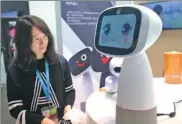  ?? CHEN YUYU / FOR CHINA DAILY ?? A visitor interacts with a robot at a high-tech exhibition in Shanghai.