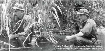  ??  ?? Two New Zealand SAS men patrolling along a riverbank in the Malay jungle in 1957, machine guns at the ready