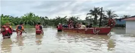  ?? ?? Fire and rescue department personnel helping to evacuate residents of Kampung Sinar Budi Baru during the flash flood on March 2.