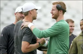  ?? STEPHEN B. MORTON — THE ASSOCIATED PRESS ?? Jaguars quarterbac­k Nick Foles, front left, greets Eagles quarterbac­k Carson Wentz before the game on Thursday in Jacksonvil­le, Fla.