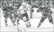  ?? Darryl Dyck Associated Press ?? ANZE KOPITAR TAKES the puck against Alex Biega, right, and other Canucks in the first period.