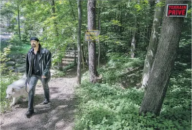  ?? PETER McCABE ?? A popular trail in Hudson has been made inaccessib­le by the sudden closure of a footbridge. The issue is raising safety concerns among residents like Seiji Gutierrez, who walks his dog on the path most days.