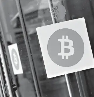  ?? AP Photo/Mark Lennihan, File ?? Bitcoin logos are displayed April 7, 2014, at the Inside Bitcoins conference and trade show in New York. The price of bitcoin, the most widely used virtual currency, rose above $10,000 on Wednesday for the first time, breaking a symbolic threshold in...