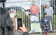  ?? AFP ?? A boy poses with cardboard cut-outs of United star Paul Pogba, left, and manager Jose Mourinho outside Old Trafford.