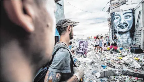  ?? FOTOS: RAMPANT PICTURES ?? Die Streetartk­ünstler Daschu (rechts) und Florian Kaiser schauen sich ihr Kunstwerk im Slum noch einmal genau an.