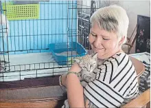  ?? BOB TYMCZYSZYN THE ST. CATHARINES STANDARD ?? Volunteer Sharon Richardson plays with one of the cats at the home of Pam Brown, who helps run Niagara Falls Community Cats, a volunteer group.