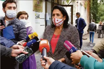  ?? Shakh Aivazov / Associated Press ?? President Salome Zurabishvi­li (center) speaks to journalist­s at a polling station in Tbilisi, Georgia. She says she is not considerin­g a pardon for former President Mikheil Saakashvil­i.