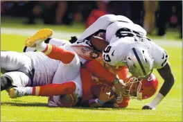  ?? CHARLIE RIEDEL — THE ASSOCIATED PRESS ?? Chiefs quarterbac­k Patrick Mahomes is sacked by Raiders defensive end Maxx Crosby, rear, and defensive end Arden Key (99) during the second half on Sunday in Kansas City.