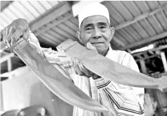  ??  ?? Ebin Adim showing the parang tembaga (copper machetes) which he has made since he was 18. - Bernama photo