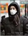  ?? ABEL URIBE/CHICAGO TRIBUNE ?? A woman wears a mask in Chicago’s Chinatown on Jan. 25