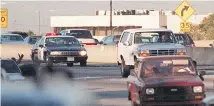  ??  ?? Motorists wave as police cars pursue the Ford Bronco driven by Al Cowlings, carrying fugitive murder suspect O.J. Simpson, on a 90-minute slow-speed car chase June 17, 1994.