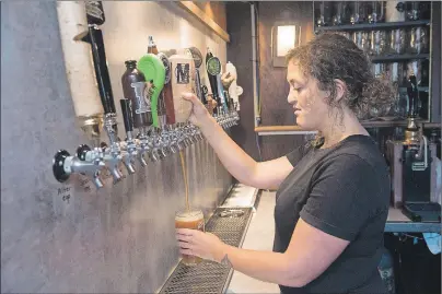  ?? THE CANADIAN PRESS/STEPHEN MACGILLIVR­AY ?? Bartender Jen Atkinson pours a Maybee craft beer at James Joyce Pub in the Crowne Plaza Hotel in Fredericto­n, N.B., last week. The pub has 25 taps dedicated to all the local craft beers and ciders.