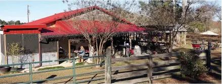  ?? Staff photos by Neil Abeles ?? MYSTERY REVEALED
■ The outdoor serenity of a barn building with lights, trees and a wood fire burning in the yard during cool weather is part of the O’Farrell Country Vineyards experience. A tasting room is here and visitors can stroll among the muscadine grape vines. The sign along FM 995 accomplish­es two tasks. It identifies the O’Farrell Country Vineyards and it gives life to the O’Farrell community, which now has one Baptist church, the graveyard and homes.