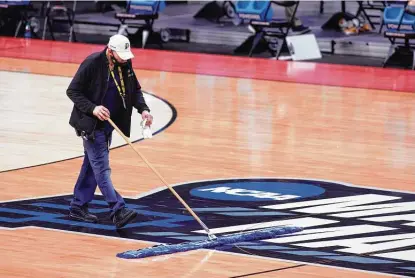 ?? Justin Casterline / Getty Images ?? An employee sweeps the NCAA March Madness Logo for Friday’s game between Tennessee and Oregon State at Bankers Life Fieldhouse in Indianapol­is. All of the 67 tournament games are televised.