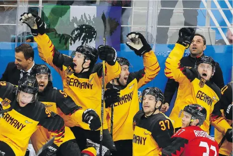  ?? LEAH HENNEL ?? Canadian defenceman Mat Robinson of Calgary gets a front-seat view of the enthusiast­ic German celebratio­n after the underdogs defeated Canada 4-3 in their semifinal match to advance to the gold-medal game against the Olympic Athletes from Russia.
