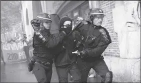  ?? AP PHOTO ?? Riot police officers detain a protester during a demonstrat­ion in Paris yesterday.