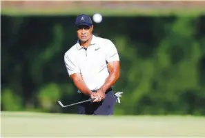  ?? Associated Press ?? ■ Tiger Woods hits a chip shot on the 11th hole during a practice round Monday for the PGA Championsh­ip golf tournament at Southern Hills Country Club in Tulsa, Okla.