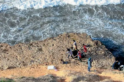  ?? PHOTO: REUTERS ?? Rescuers carry a bag containing the body of a migrant at the coast of Tajoura, east of Tripoli, Libya.