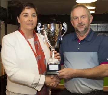  ??  ?? Deirdre Kehoe (niece) presents the Jim O’Neill memorial perpetual cup to winner Martin Kehoe after the competitio­n in his memory organised by the Three Bullet Gate Golf Society in New Ross.