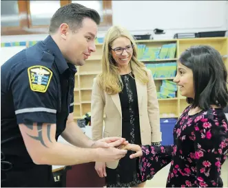  ?? LEAH HENNEL ?? Eleven-year-old Maryam Basharat meets EMT Paul Emmerson at Balmoral School with her principal Liana Appelt on Friday. A ceremony was held to recognize school staff and paramedics who helped save the young student’s life after she went into cardiac arrest while outside running with her class at the school.