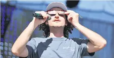  ?? ?? A. David Weigel, Intuitive Planetariu­m director at the US Space & Rocket Centre, demonstrat­es how to wear eclipse glasses for the solar eclipse, at the Total Eclipse of the Heart festival, in Russellvil­le, Arkansas.