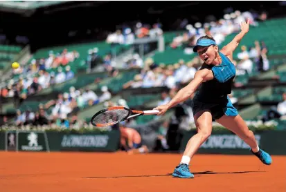  ??  ?? Simona Halep stretches for a backhand return to Spain’s Garbine Muguruza during their French Open semifinal at Roland Garros in Paris yesterday. The Romanian top seed won 6-1, 6-4. — Reuters