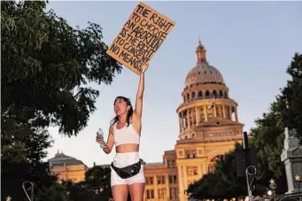  ?? Sam Owens/Staff file photo ?? Abril Lazaro, a UT-Austin student, signals her anger at the Supreme Court’s decision to overturn Roe v. Wade in June. Abbott signed the trigger law that banned abortion in Texas.