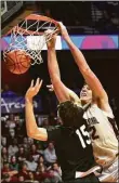  ?? Christian Abraham / Hearst Connecticu­t Media ?? Bristol Central's Donovan Clingan, right, dunks the ball during the Division II state championsh­ip game.