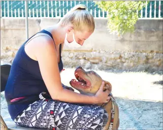  ??  ?? Volunteer Stephanie Horsfall pets Angel
during a walk on Wednesday at the emergency pet shelter run by Yuba-sutter
Domestic Animal Assistance at the Yuba
Sutter Fairground­s.
