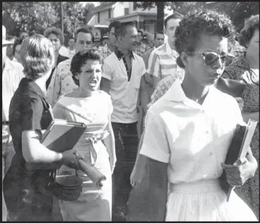  ?? Will Counts/Arkansas Democrat-Gazette file photo via AP ?? In this Sept. 4, 1957, file photo, students of Central High School in Little Rock, Ark., including Hazel Bryan, shout insults at Elizabeth Eckford as she calmly walks toward a line of National Guardsmen. The Guardsmen blocked the main entrance and...