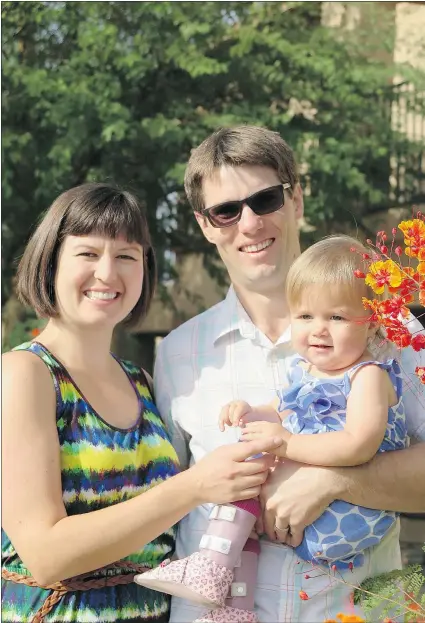  ??  ?? Parents Meredith and Andrew Essex hold their 18-month-old daughter Natalie, who was recently diagnosed with spinal muscular atrophy, a progressiv­e neuromuscu­lar disease. An online fundraisin­g campaign is helping the family deal with the rising...