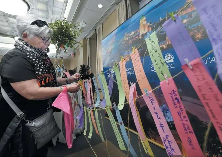  ?? PHOTO DIDIER DEBUSSCHÈR­E ?? Les citoyens étaient invités à rédiger un message porteur d’espoir pour l’accrocher sur l’« arbre de la paix ». À l’image de cette femme, ils ont été nombreux à témoigner leur sympathie sur ces petits bouts de papier.