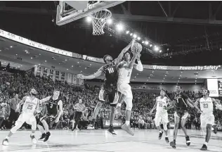  ?? Brett Coomer / Staff photograph­er ?? UH guard Nate Hinton, right, takes the ball to the basket against Oregon’s Victor Bailey Jr. before a capacity crowd at Saturday night’s unveiling of the Fertitta Center.