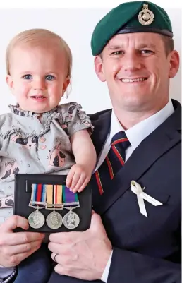  ??  ?? Medals: Mr Goodman with 15-month-old daughter Freya