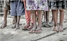  ??  ?? Children with muddy feet: With their mothers far away, many children face neglect and abuse