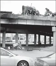  ?? AP/The Dallas Morning News/DAVID WOO ?? The cab of an 18-wheeler dangles from an overpass after a fiery accident involving several vehicles Friday in Dallas. The big rig’s driver was killed.