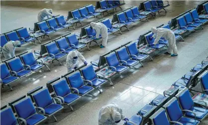  ??  ?? Workers disinfect a waiting area at Wuhan railway station, which has been closed since January. Photograph: Reuters