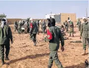  ?? /AFP Photo ?? Atrocity: Soldiers attend to the wounded after a suicide bomb attack on a camp grouping former rebels and pro-government militia in troubled northern Mali.