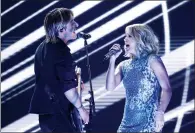  ?? PHOTO BY MATT SAYLES/INVISION/AP ?? Keith Urban and Carrie Underwood perform "The Fighter" at the 59th annual Grammy Awards on Sunday in Los Angeles.
