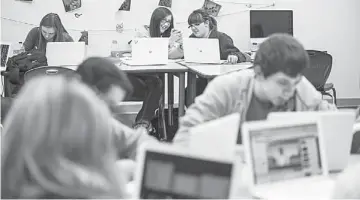  ??  ?? DONATED COMPUTERS: Seniors Jones, 17, (centre) and Becky Stringer, 18, share a photo on a cellphone during a short break in class. In the wake of a tornado that devastated Joplin, the United Arab Emirates donated US$500,000 enabling the school district...