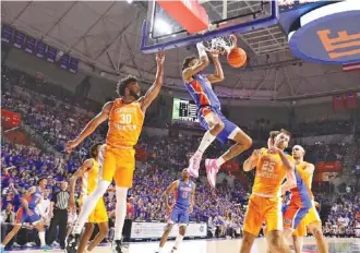  ?? FLORIDA ATHLETICS PHOTO ?? Florida’s Alex Fudge dunks between Tennessee’s Josiah-Jordan James (30) and Santiago Vescovi (25) during Wednesday night’s 67-54 win by the Gators. The Vols next host Auburn on Saturday afternoon.