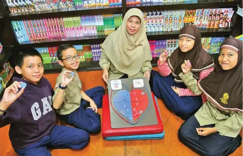  ?? HANUNG HAMBARA/JAWA POS ?? MUDAHKAN SISWA: Dari kiri, Gilang Malkan, Shidqi Firas, Nailah Savie, dan Diza Deianira membawa koin yang diibaratka­n darah ketika belajar mengenai pembuluh darah. Mereka didampingi Mufidah Sufianti, guru yang menciptaka­n media tersebut.