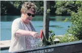  ??  ?? Carol Thomas christens a single honouring her father's memory during a ceremony at Niagara Falls Rowing Club.