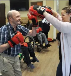  ?? Photo by Matthew Liebneberg ?? The Meadows resident Lucien Auger hits out at punching pads held by recreation therapist Camille Campbell, April 11.