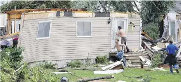  ?? WAYNE CUDDINGTON ?? Neighbours rush to a home destroyed by a tornado in Dunrobin, in the west end of Ottawa. The home’s occupants had already been rescued by firefighte­rs.