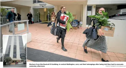  ?? PHOTO: ROBERT KITCHIN/STUFF ?? Workers from this Boulcott St building, in central Wellington, carry out their belongings after being told they had to evacuate yesterday afternoon.