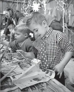  ??  ?? Angelo Palma, 5, of Blacklick, paints his wooden toy.