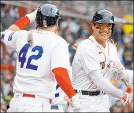  ?? Mary Schwalm The Associated Press ?? Yu Chang, right, celebrates with Red Sox teammate Justin Turner after hitting a tworun homer in Boston’s win over the Angels on Saturday. Chang also hit a two-run single.