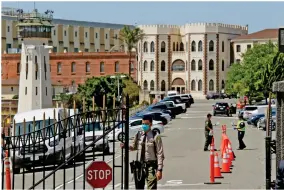  ?? AP PHOTO BY ERIC RISBERG ?? FILE - In this July 9, 2020, file photo, a correction­al officer closes the main gate at San Quentin State Prison in San Quentin.